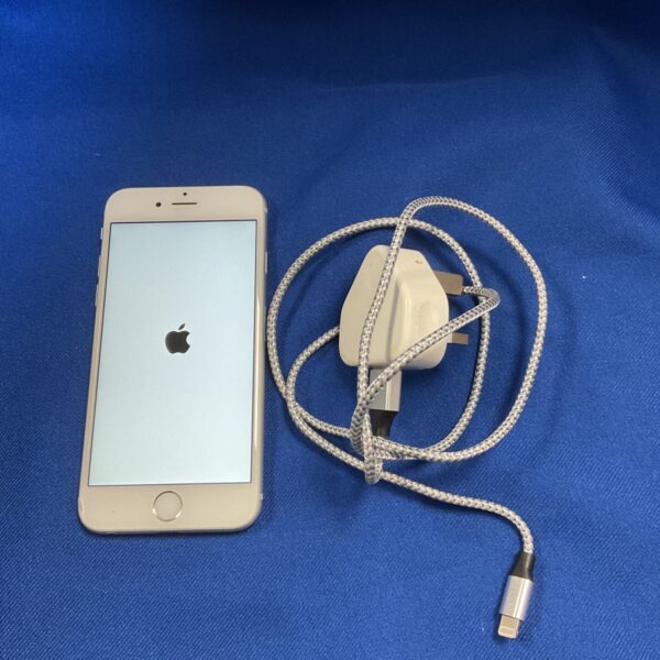 Gold Apple iPhone S mobile phone with charging cable.