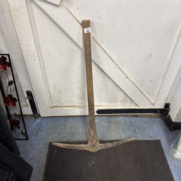 Vintage pick axe with wooden handle and steel head.