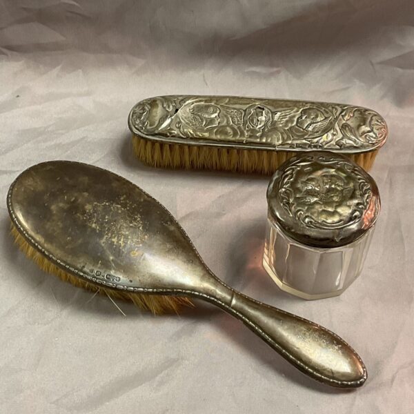 Antique silver dressing table set with floral details.