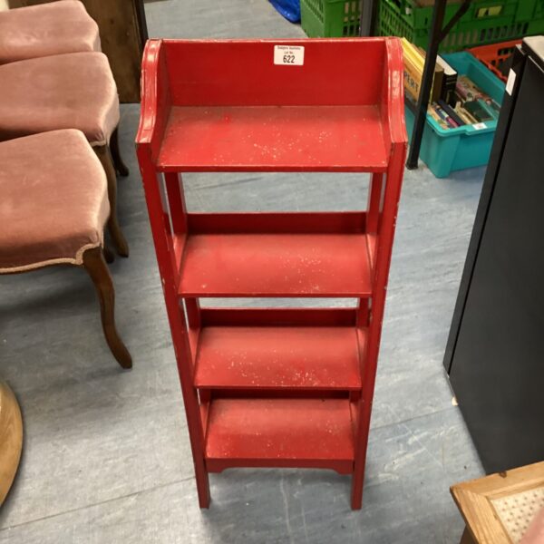 Vintage red child's bookshelf for bedroom storage.