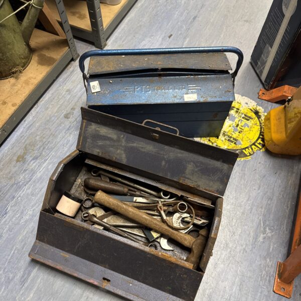 Vintage metal toolbox with tools inside, antique workshop storage.