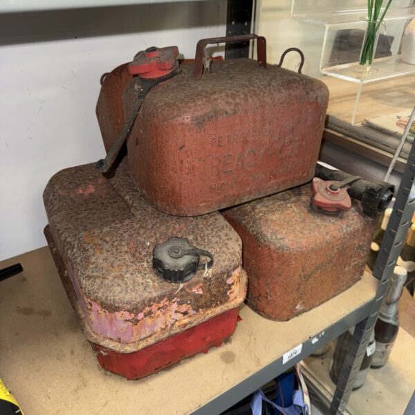 Set of four vintage rusty jerry cans for fuel storage.