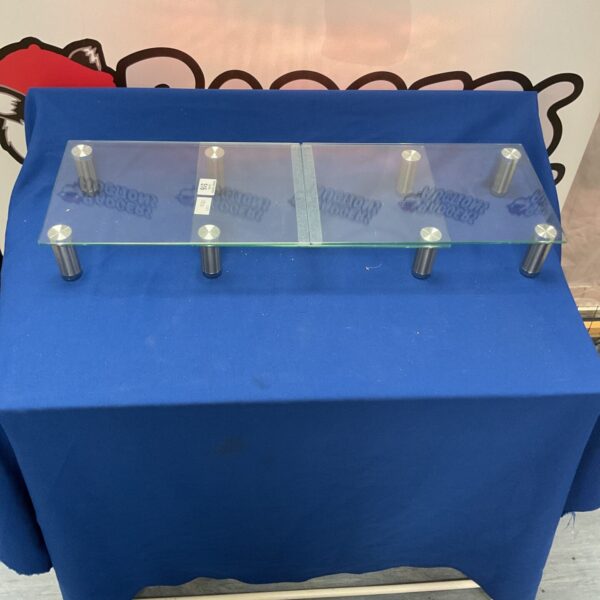 Clear glass laptop stand for ergonomic desk setup.
