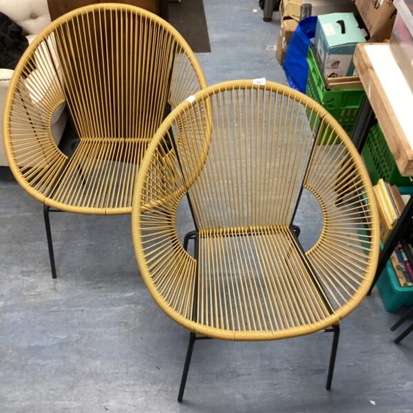 Two yellow string egg chairs with black metal legs.