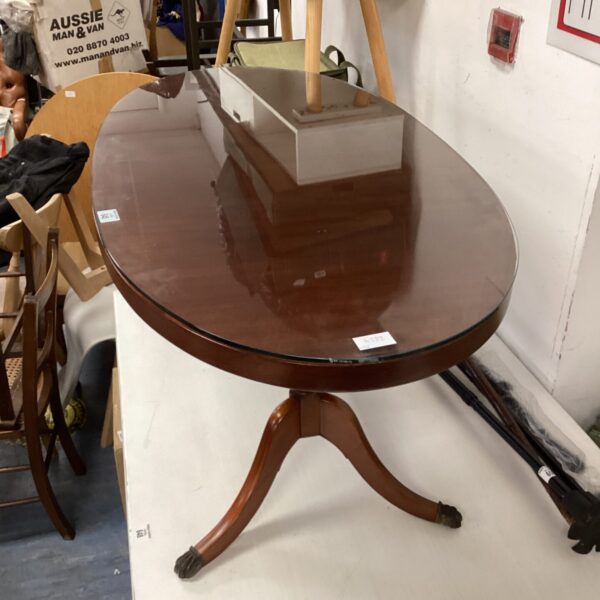 Elegant Regency coffee table with glass top and claw feet.