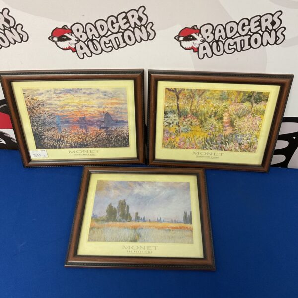 Framed Monet print of a golden wheat field landscape.