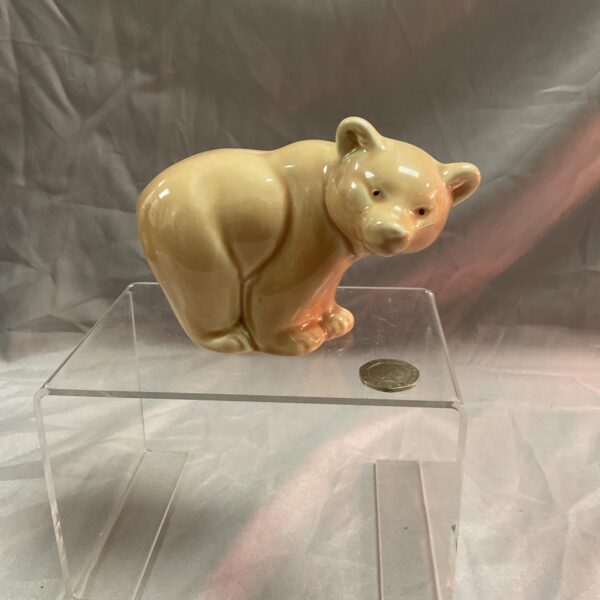 Vintage Poole Pottery bear figurine on a clear stand.