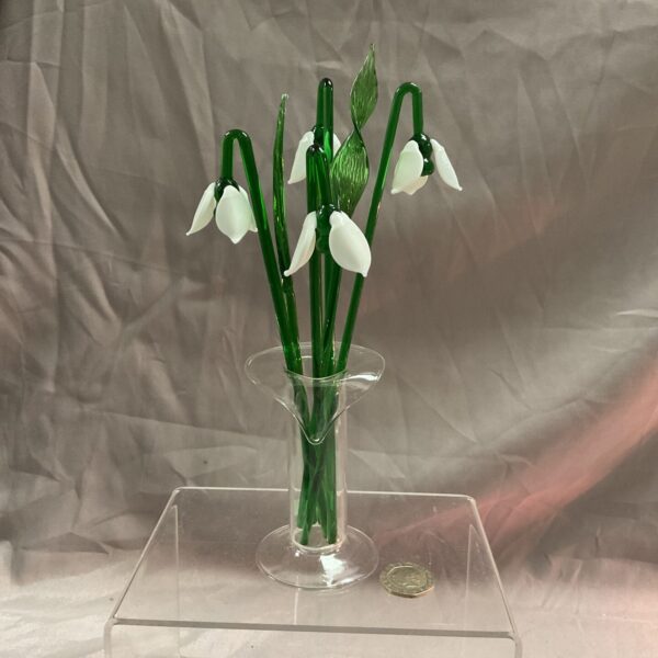 Clear glass snowdrop cocktail stirrer with delicate floral design.