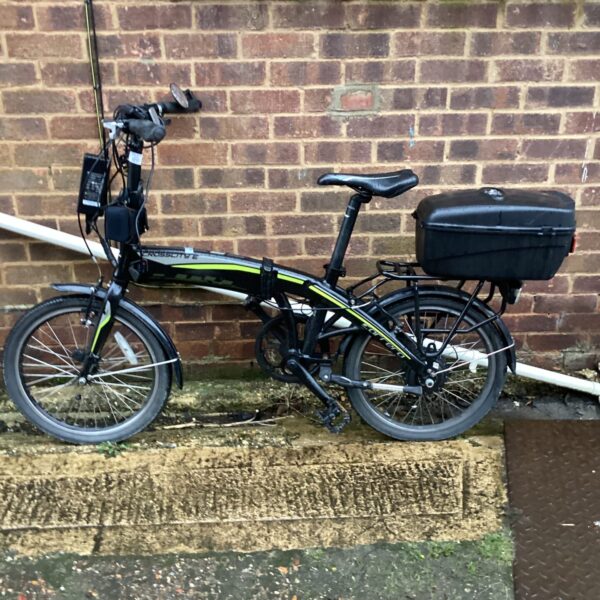 Black Carrera Crosscity e-bike with pannier rack, folding bicycle.