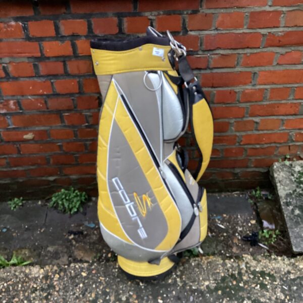 Vintage silver and yellow Cobra golf bag for carrying clubs.