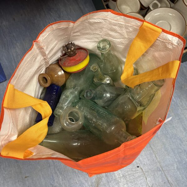 Large lot of vintage glass bottles, varying shapes and colours.