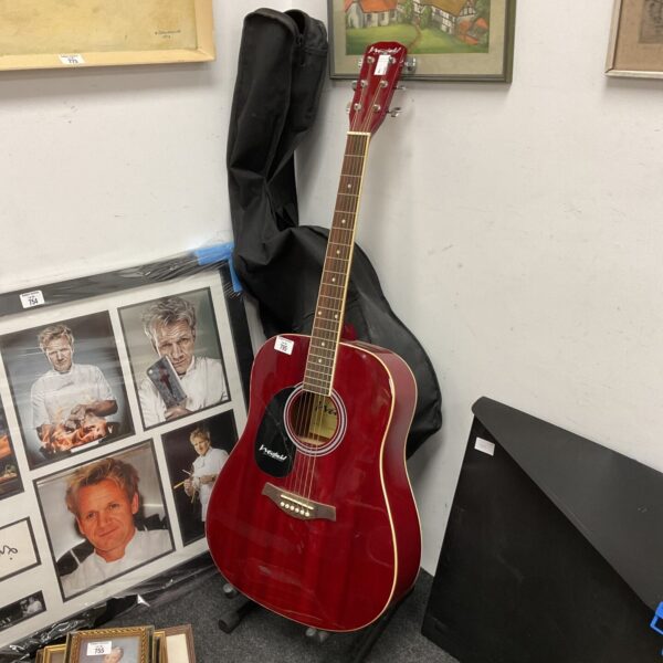 Red Westfield acoustic guitar with case, musical instrument.