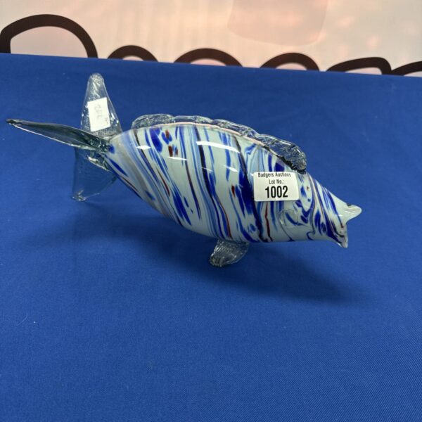 Vibrant Murano glass fish sculpture with blue and white swirls.