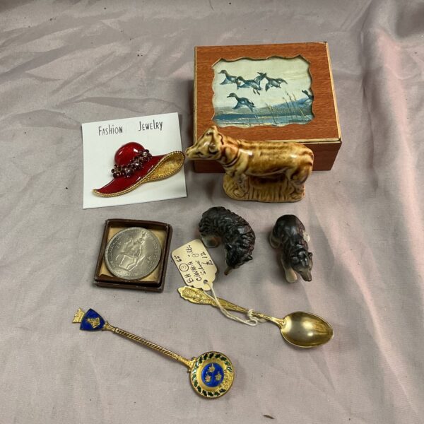 Vintage silver spoons and ceramic dog figurines in a collectible lot.