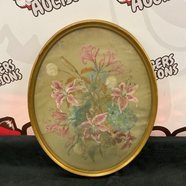 Vintage floral oil painting in an ornate oval gilt frame.