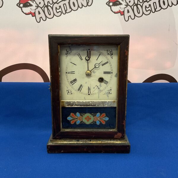 Antique American mantle clock with wooden case and Roman numerals.