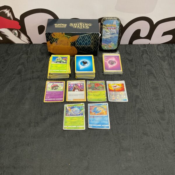 Pokemon card collection with holographic cards and a storage tin.