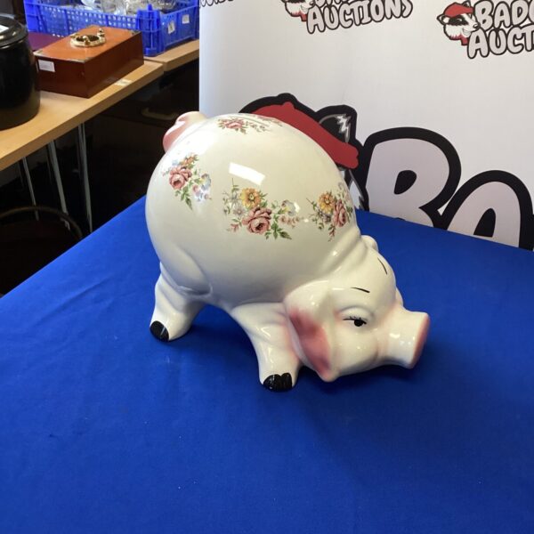 Large vintage porcelain piggy bank with floral decoration.