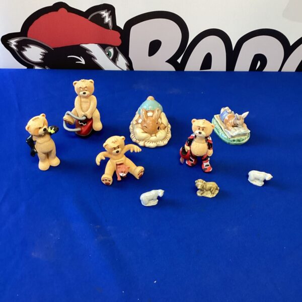 A lot of vintage bear and animal figurines on a white surface.