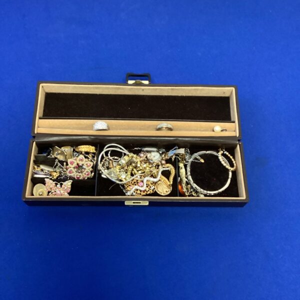 Vintage jewellery box filled with assorted costume jewellery pieces.