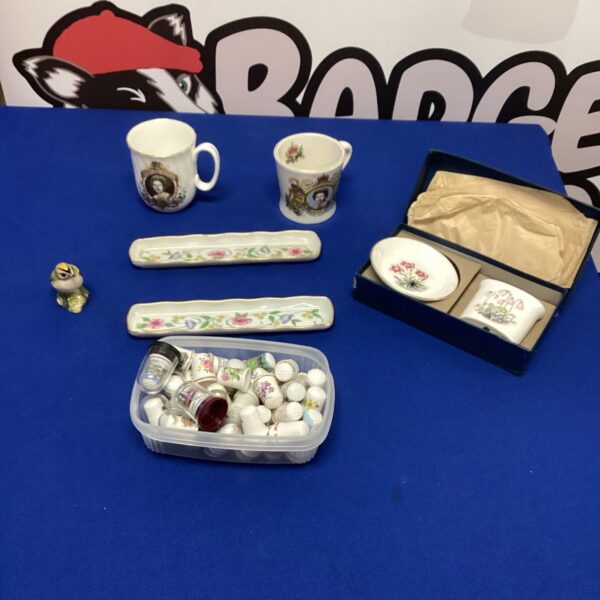 Vintage thimble collection with a Beswick bird figurine on display.