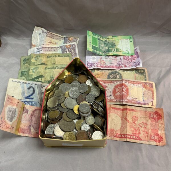 Assorted world coins and banknotes in a vintage tin.