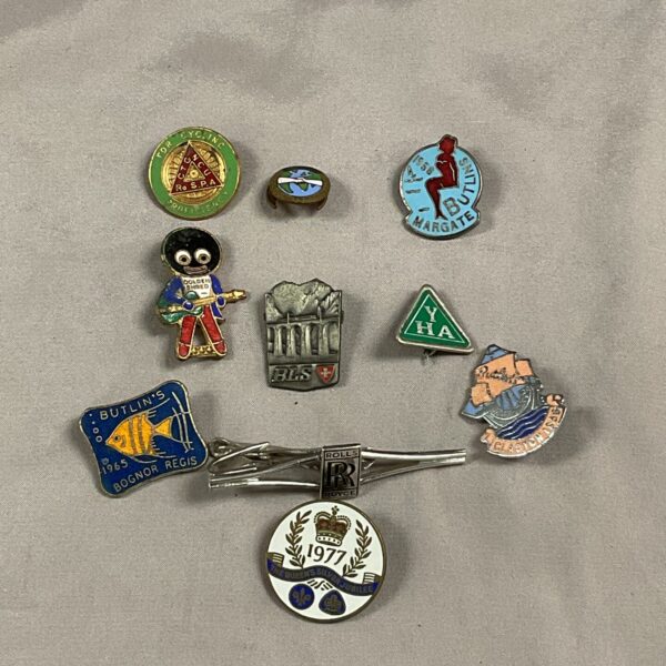 Vintage pin badges collection including Butlins and golly motifs.