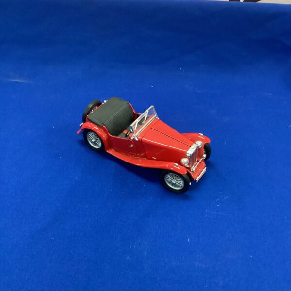 Red diecast model of a vintage MG TC Midget sports car.