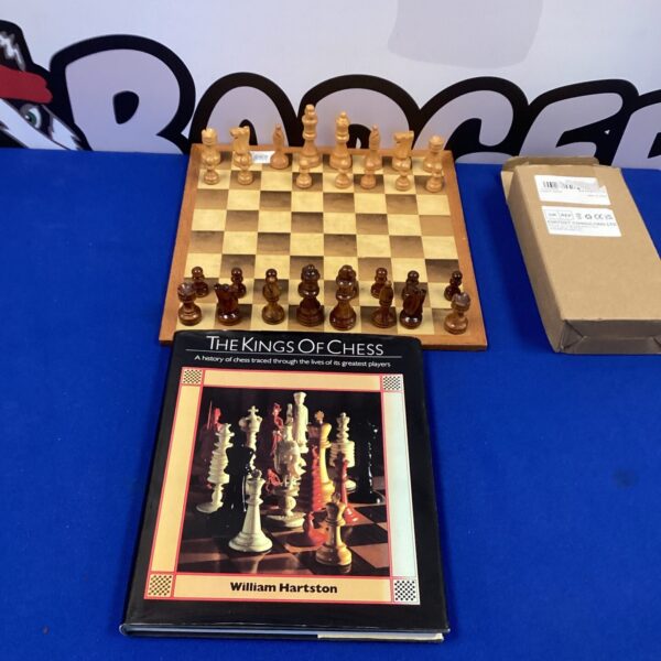 Vintage wooden chess set with board and book.