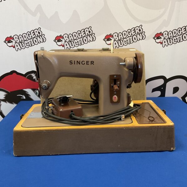 Vintage Singer electric sewing machine in used condition.