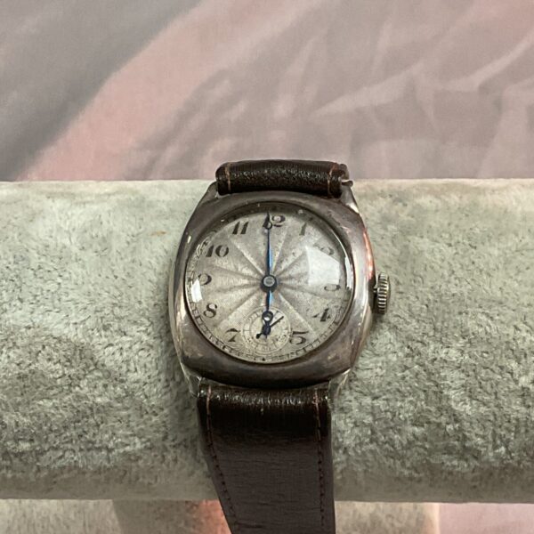 Front view of a vintage mechanical wristwatch with leather strap.