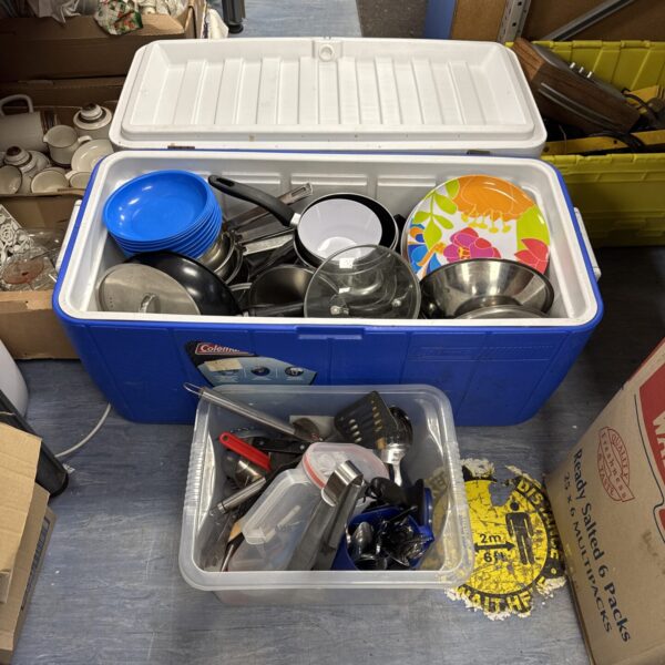 Large Coleman insulated chest filled with kitchenware and cutlery.