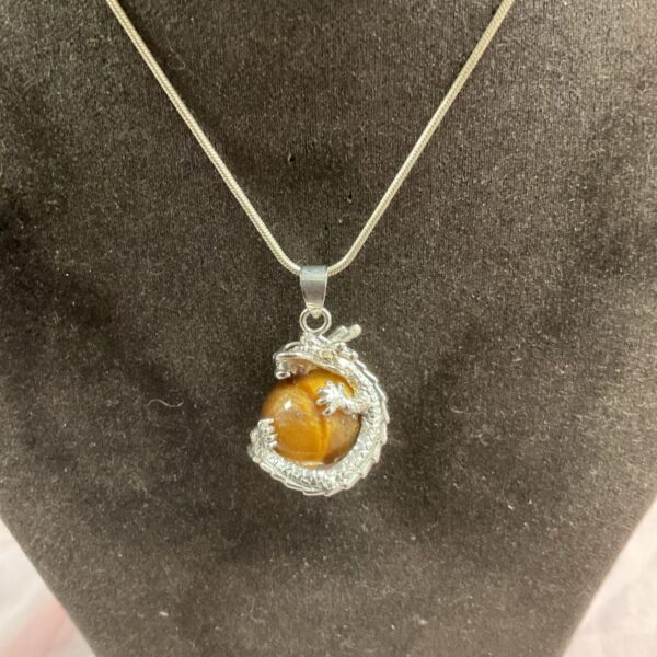 Detailed sterling silver dragon necklace with tiger's eye pendant.