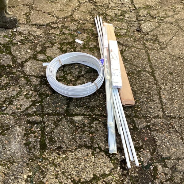 Metal curtain rail and electrical conduit bundle for DIY projects.