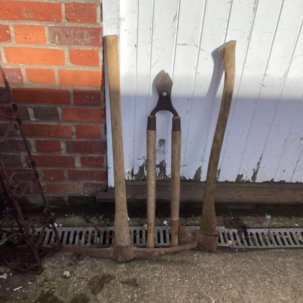 Vintage garden tool set including a pickaxe and loppers.
