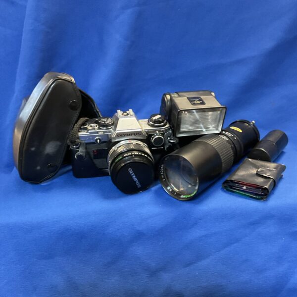 Vintage Olympus OM10 35mm film camera with lenses displayed.