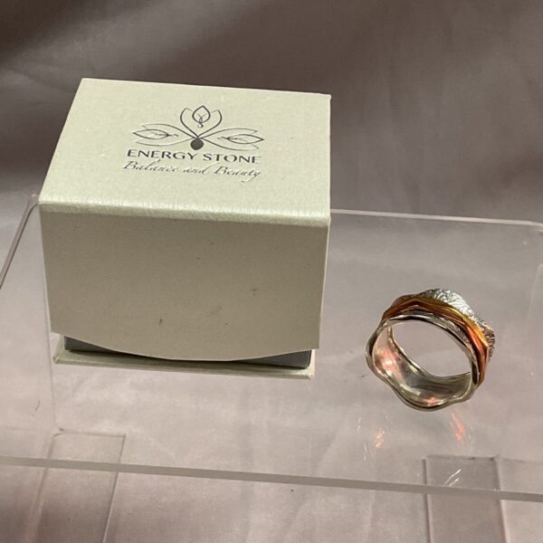 Silver spinner ring with copper and brass rotating bands.