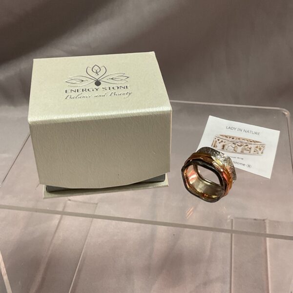 Silver ring with spinning brass and copper bands.
