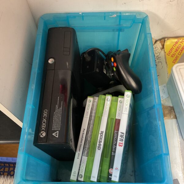 Xbox 360 E console with controllers and games presented in a lot.