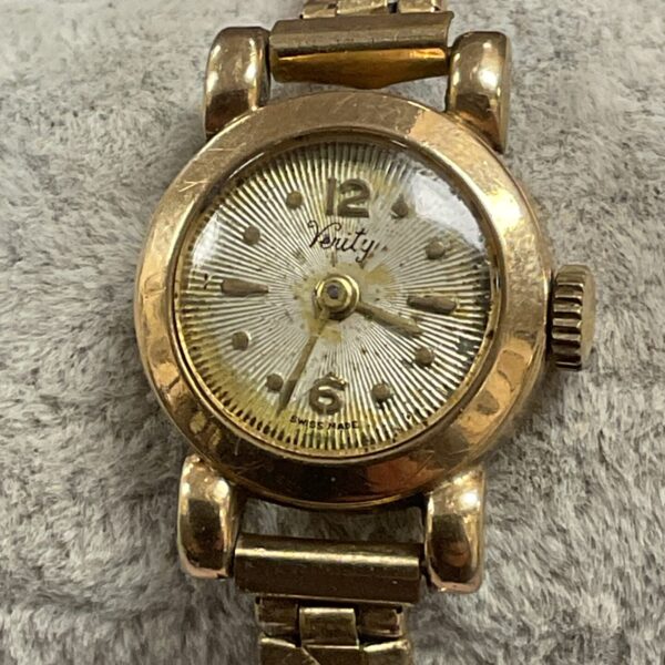 Close-up of vintage 9ct gold wristwatch with pale dial.