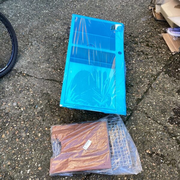 New stainless steel kitchen sink with fitting kit in plastic packaging.