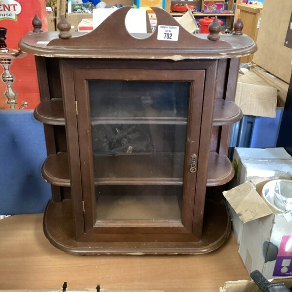 Antique wooden display cabinet with glazed door and tiered shelves.