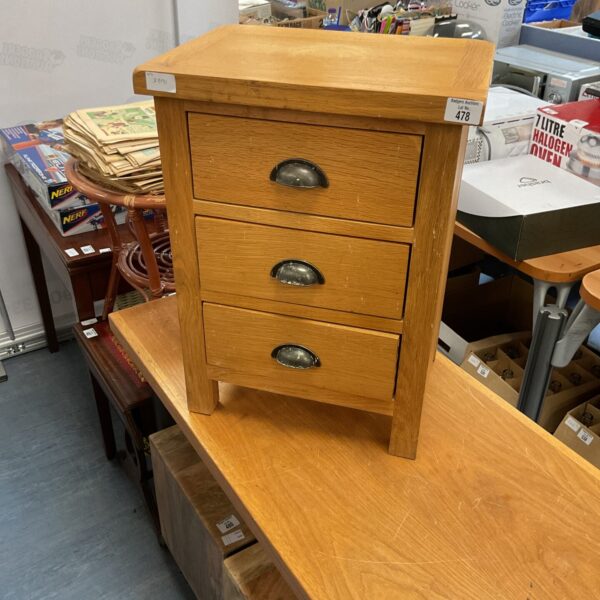 Vintage pine bedside cabinet with three drawers, ideal for bedroom storage.