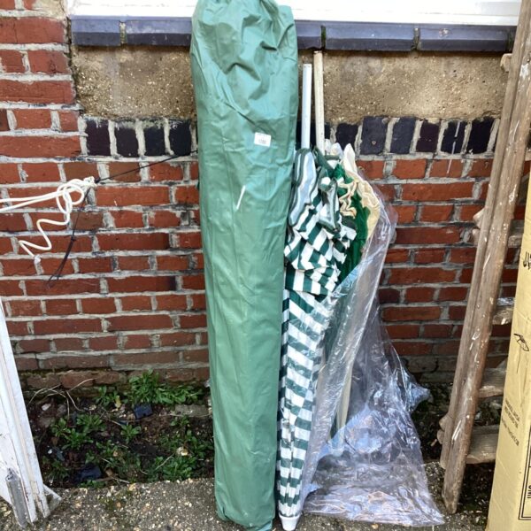 Three vintage green garden parasols stacked together.