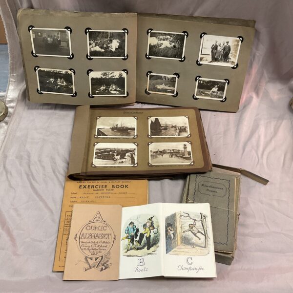 Vintage ephemera collection featuring photo albums and a comic alphabet book.