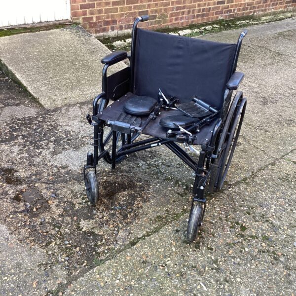 Front view of an extra wide wheelchair, showing its padded seat and frame.
