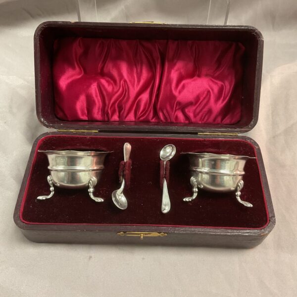 Cased pair of antique silver relish pots and spoons.