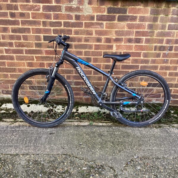 Blue RockRider ST 100 mountain bike on display.
