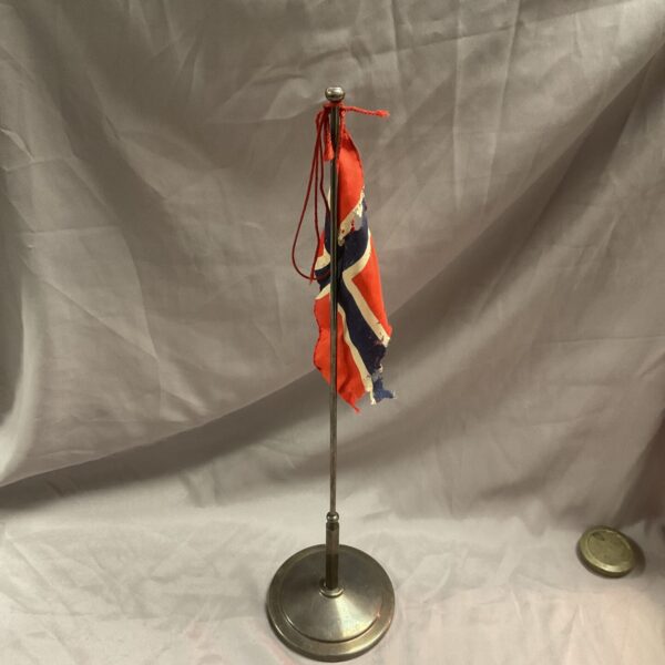 Vintage silverplate Norwegian table flag pole with flag displayed.