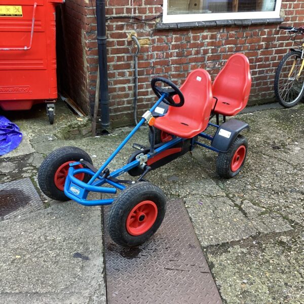 Red Berg two-seater go kart in a garden setting.